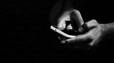 grey scale photo of person holding smartphone
