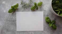 top view photo of paper near basil leaves