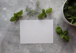 top view photo of paper near basil leaves